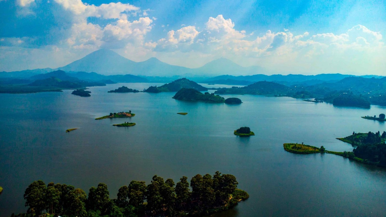 Islands scattered across Lake Bunyonyi with volcanoes on the far shore