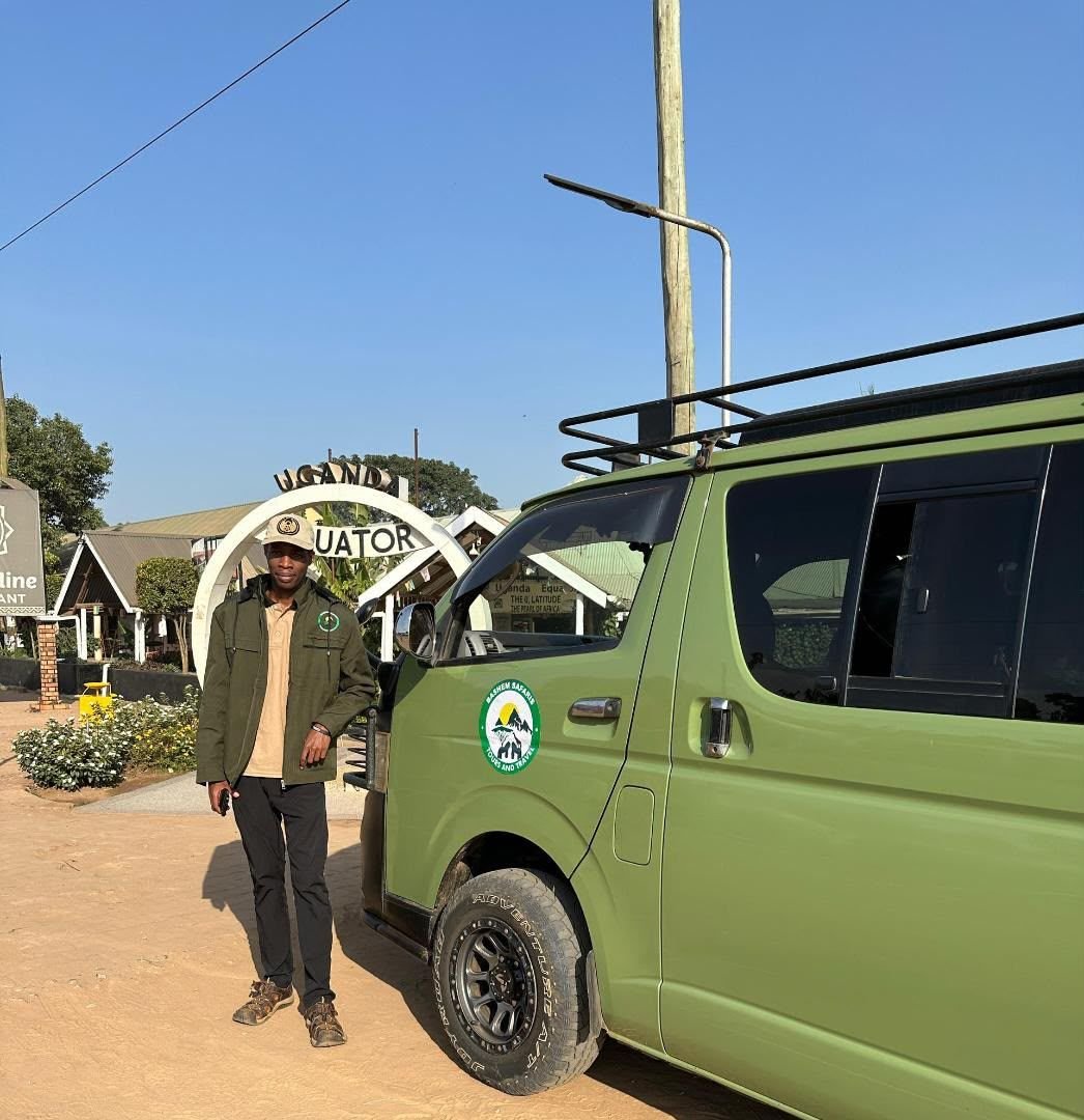 A Bashem guide beside a company van at the Uganda Equator monument